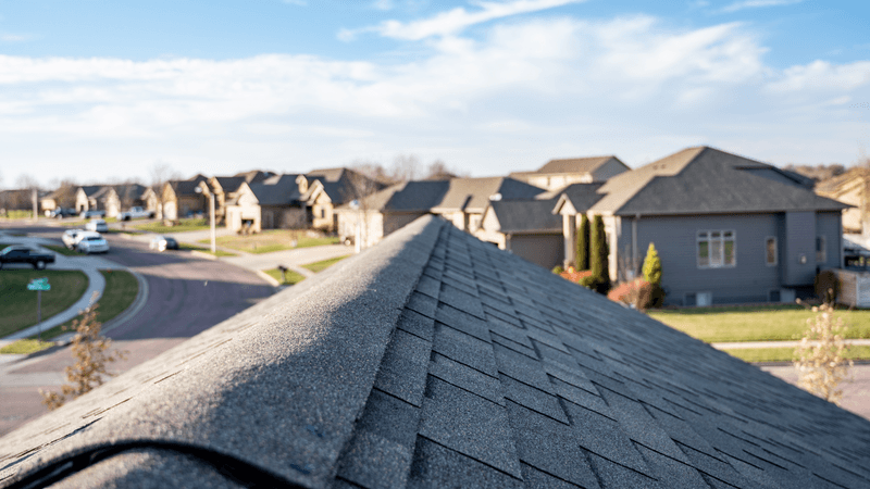 view of a nice neighborhood from new professionally installed roof on a sunny day