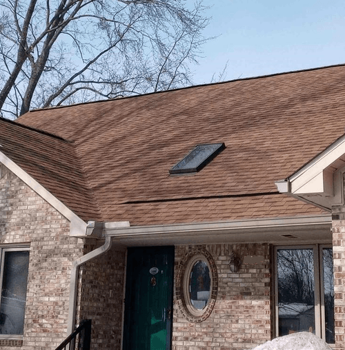 red and brown roof with skylight on gradient red white and brown brick home